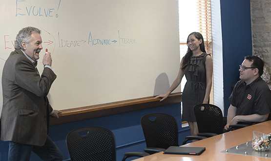 man and woman at white board in a conference room
