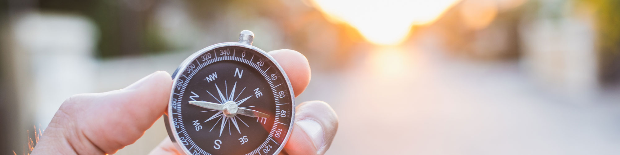 Man holding compass at crossroad