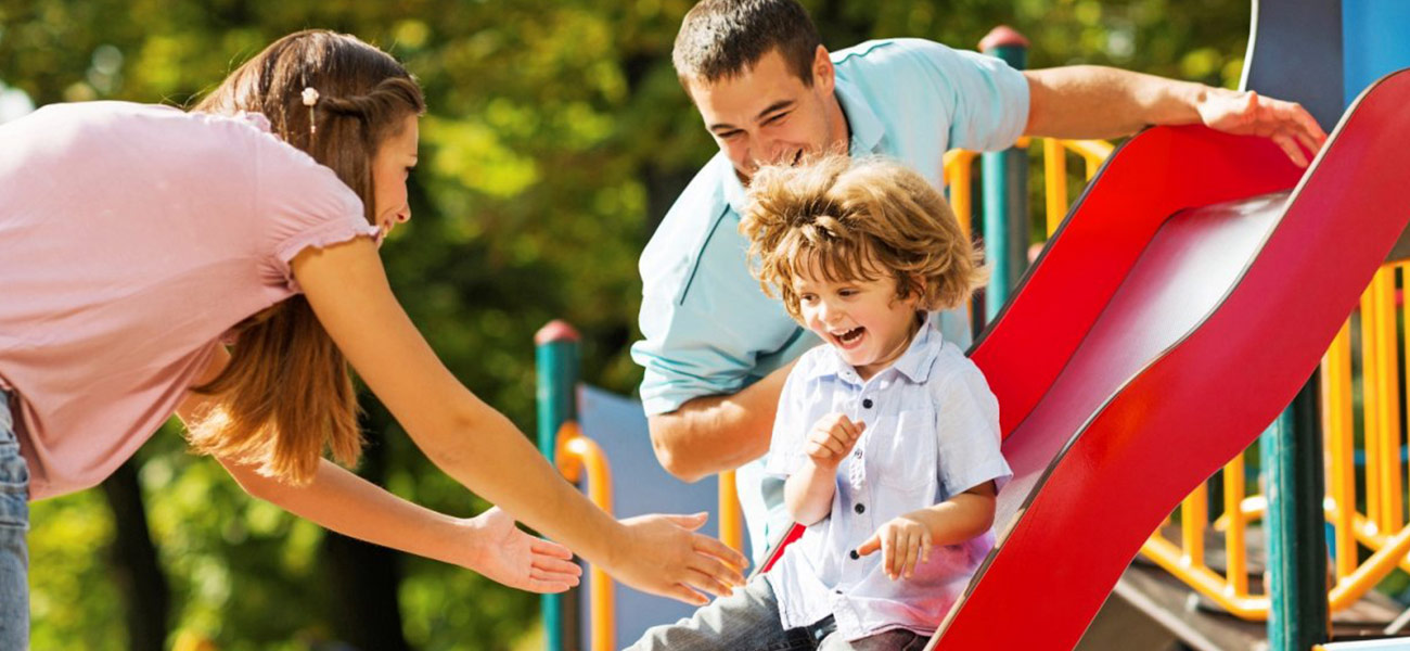 Parents catching healthy child on slide
