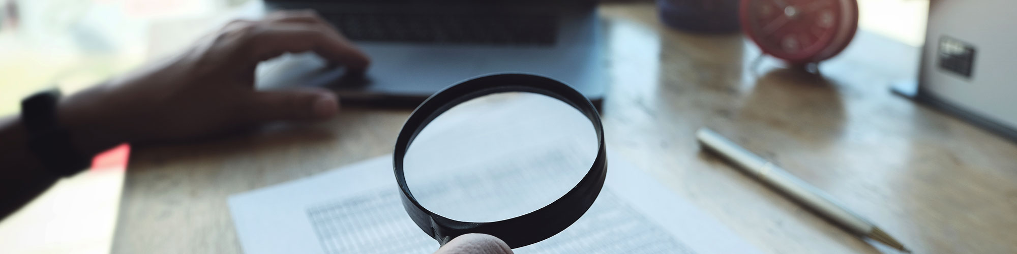 Man holding magnify glass on computer