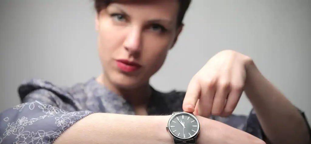 woman pointing to watch