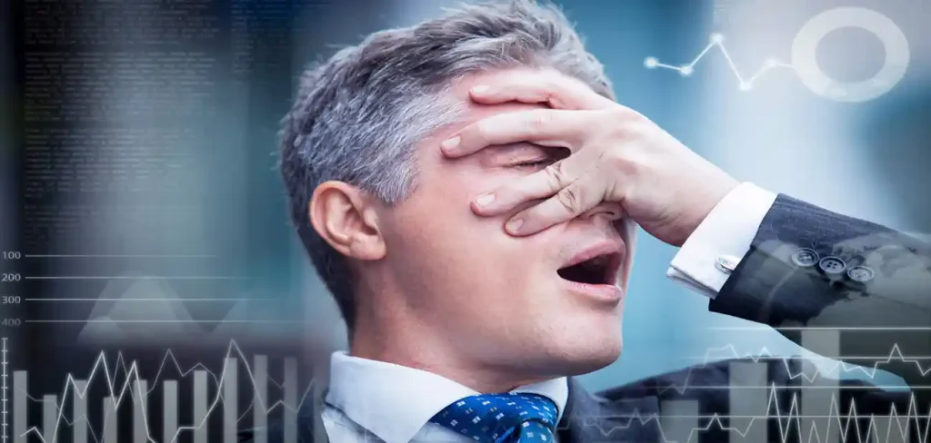 man in tie holding hand on face in agony