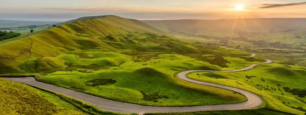 rolling green hills with sunset
