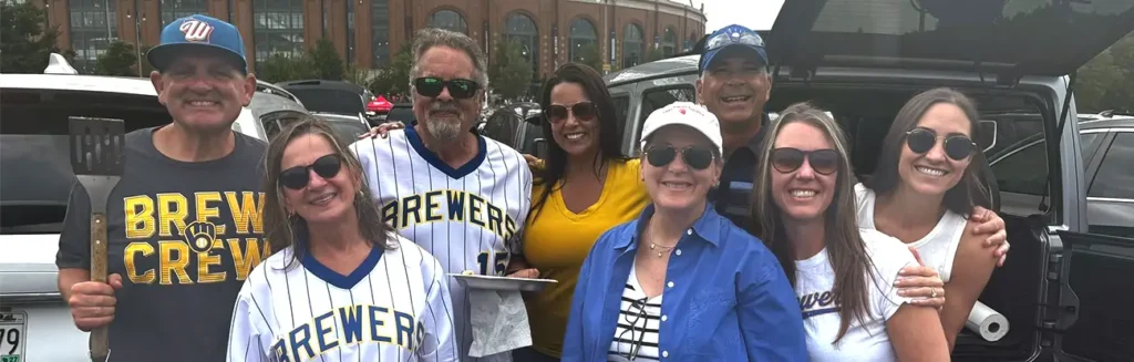 Team Trivera members wearing Milwaukee Brewers apparel gather outside the ballpark before attending a game together.